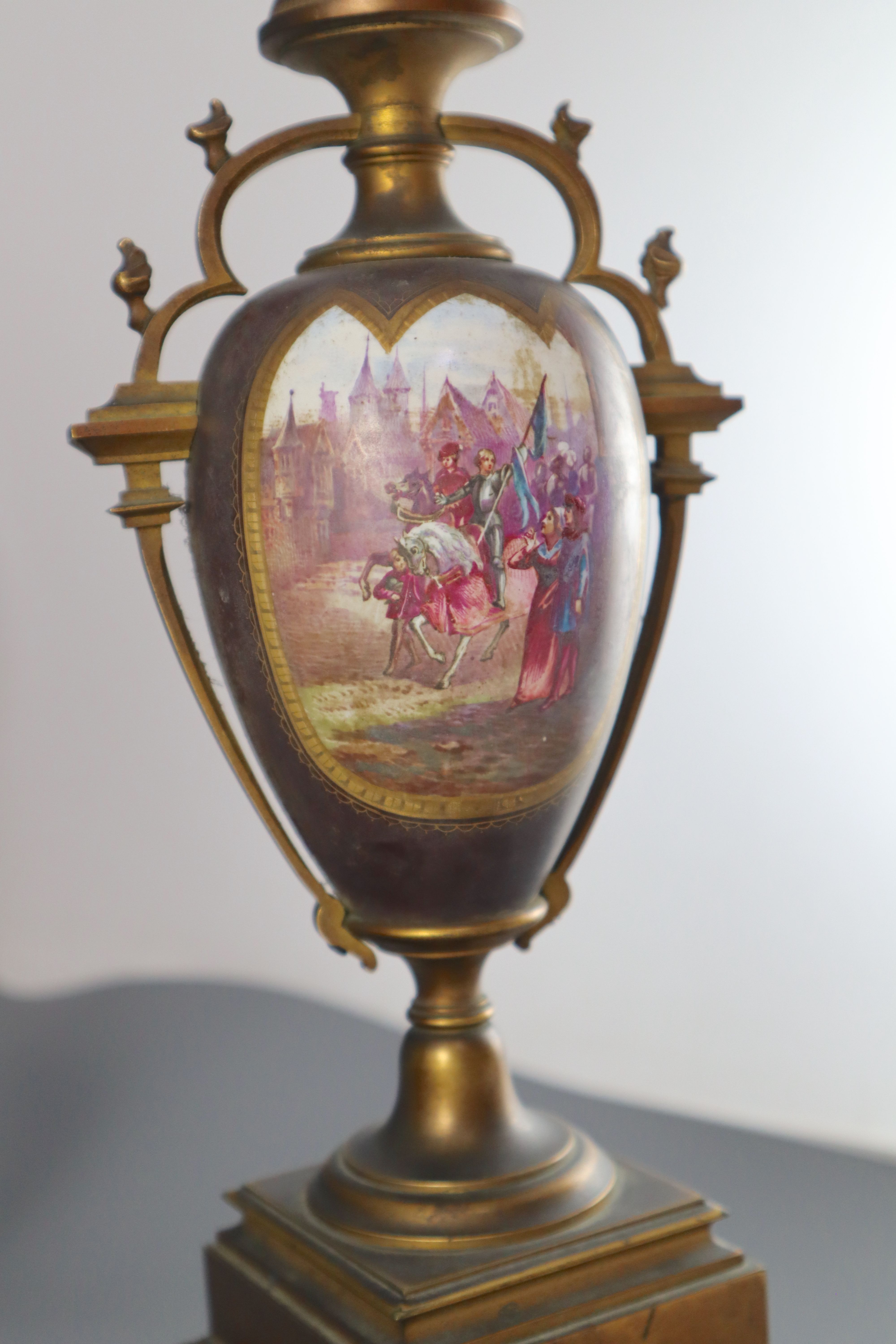 A 19th century French ormolu and enamelled porcelain clock garniture, clock height 13.75in. urns 11.5in. overall on both plinths 17in.